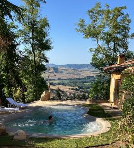 mężczyzna w basenie na podwórku w obiekcie B&B Cal Torello w mieście Urbino