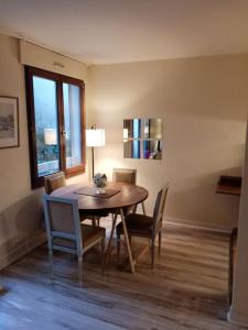 a dining room with a table and chairs and a window at Studio Cosy avec terrasse face au parc des expositions in Vanves