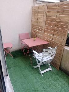 a pink table and two chairs and a pink table and chairs at Studio Cosy avec terrasse face au parc des expositions in Vanves