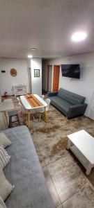 uma sala de estar com um sofá e uma mesa em Lalúan departamento temporario em Ushuaia