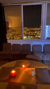 um quarto com uma mesa com uma vela e uma janela em Petra Everest Hostel em ‘Ayn Amūn