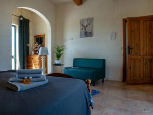 a bedroom with a blue bed and a blue couch at Moonshine Villa in Nadur