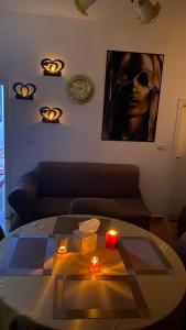 uma sala de estar com uma mesa com velas e um sofá em Petra Everest Hostel em ‘Ayn Amūn