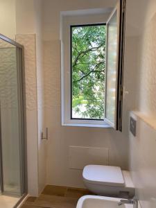 a bathroom with a toilet and a window at Marina House - Iulm Navigli San Paolo in Milan