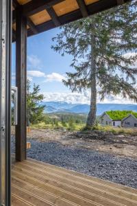 un portico con vista su un albero e sulle montagne di Unique new cabin by Hafjell & Skei with stunning view a Tretten Altre 34 foto