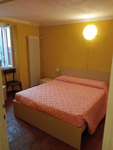 a bedroom with a bed with a red comforter at Casa Violetta, Historic Center in Colonno