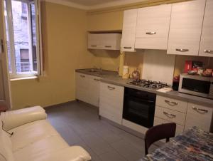 a kitchen with white cabinets and a stove top oven at Casa Violetta, Historic Center in Colonno