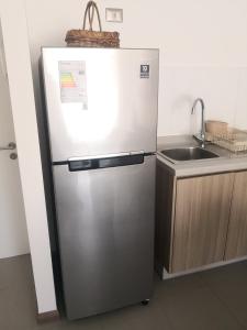 a stainless steel refrigerator in a kitchen with a sink at Sensacional Departamento cerca Zofri 2 Habitaciones 2 Baños Iquique in Iquique