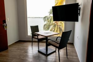 stół i krzesła w pokoju z oknem w obiekcie Hotel Caribbean Cartagena w mieście Cartagena de Indias