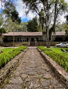 a stone path in front of a house with a building at Hotel Hacienda Suescún in Tibasosa