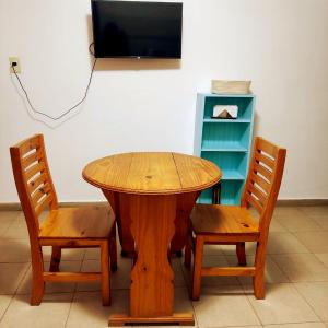 a wooden table with two chairs and a tv at Mi depa en Esquel in Esquel