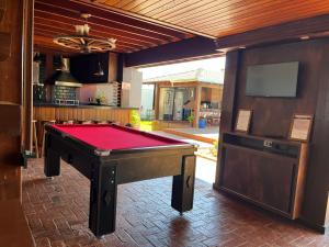 a pool table in a living room with a tv at Recanto Reino Encantado in Olímpia