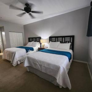 two beds in a bedroom with a ceiling fan at 1 bedroom (2 Beds), 1 Bath with Kitchen at IMG in Bradenton