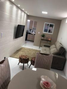 ein Wohnzimmer mit Sofa und Tisch in der Unterkunft CASA PARA TEMPORADA CAMPINA GRANDE! in Campina Grande