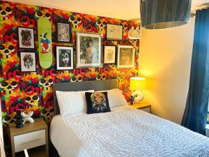 a bedroom with a bed and a colorful wall with pictures at Artistic stunning apartment city view in Clooney Park