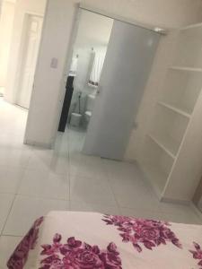 ein weißes Zimmer mit einem Bett mit Blumen darauf in der Unterkunft CASA PARA TEMPORADA CAMPINA GRANDE! in Campina Grande