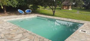 a swimming pool with two chairs and a pair at Bwana Tembo Safari Camp in Paraa