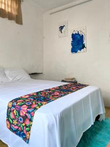 - une chambre avec un lit et une couverture colorée dans l'établissement La casa de las muñecas, à Mérida