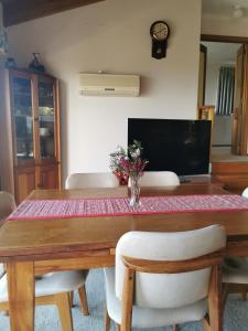 a dining room table with a vase of flowers on it at Flinders Island Masters Quarters - Lady Barron in Lady Barron +23 photos