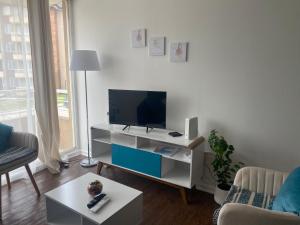 a living room with a flat screen tv on a stand at Apartamento altos del boldo in Curicó