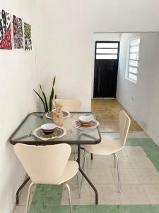 une salle à manger avec une table et des chaises blanches dans l'établissement La casa de las muñecas, à Mérida