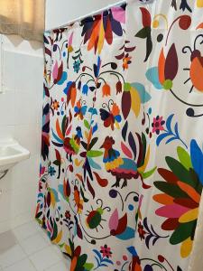 - un rideau de douche avec un motif floral dans la salle de bains dans l'établissement La casa de las muñecas, à Mérida