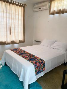 - une chambre avec un grand lit blanc et une couverture dans l'établissement La casa de las muñecas, à Mérida
