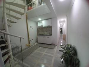 a white hallway with a staircase and a kitchen at Hostal Emanuel in Aracataca