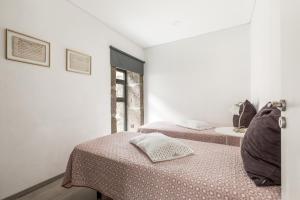 two beds in a room with white walls at Quinta Barqueiros D'Ouro - Casa da Música in Mesão Frio +64 photos