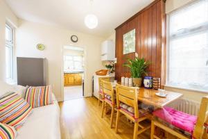 a kitchen and dining room with a table and chairs at Wembley Arch View, 4-Bed House, Drive for 2 cars in London