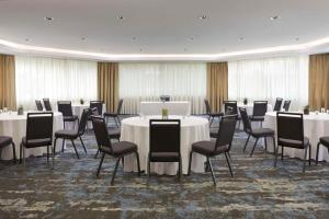 Best Western Parkway Hotel Toronto North في ريتشموند هيل: قاعة اجتماعات مع طاولات وكراسي وطاولة