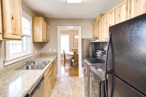 una cucina con armadi in legno e frigorifero nero di Charming Tullahoma Stay with Great Walkable Location a Tullahoma