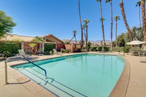 a large swimming pool with palm trees in the background at Palm Desert Vacation Rental with Pool Access! in Palm Desert