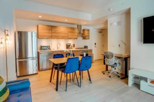 a kitchen with a wooden table and blue chairs at San Francisco Condo Less Than 1 Mi to Union Square! in San Francisco