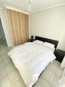 uma grande cama branca num quarto branco em Offline em Boksburg