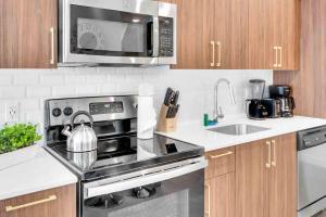 a kitchen with a stainless steel stove and a microwave at Modern Unit in Downtown Miami With Free Parking in Miami