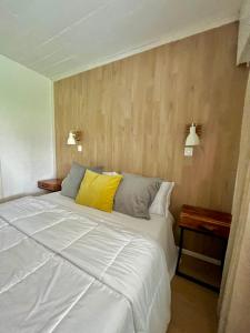a bedroom with a large white bed with a yellow pillow at Puerta Azul in Punta del Este