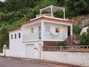 una casa bianca con un balcone sopra di Villa de Bruma Faial da Terra a Faial da Terra