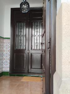 a large wooden door in a room with a wall at LA CASA DEL VIENTO ATQ in Antequera