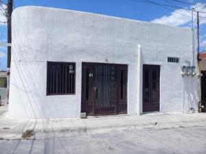 ein weißes Gebäude mit braunen Türen auf einer Straße in der Unterkunft Depa privado en Guadalupe, céntrico y cómodo. in Monterrey