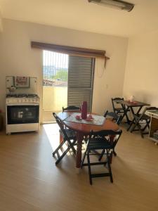 a living room with a table and chairs and a kitchen at Hostel Salus in Barueri