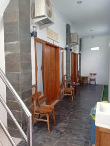 a waiting room with wooden chairs and tables at D'TRANSIT in Nusa Penida