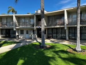 un edificio con palmeras delante en Valley Inn, en Mission Hills