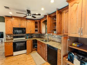 a kitchen with wooden cabinets and a ceiling fan at Sun & Fun 3BR Beach Home with Pool & Tiki Bar in Jacksonville