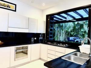 a kitchen with a sink and a large window at Casa HESTIA Condominio Campestre el Peñon Girardot in Girardot