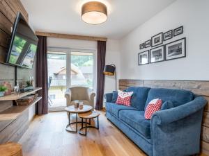 een woonkamer met een blauwe bank en een tafel bij Ski Nature Apartment Lungau Top 15 in Mauterndorf