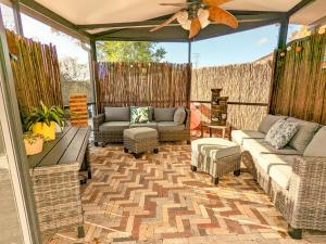 un porche cubierto con sofás y sillas en Sun & Fun 3BR Beach Home with Pool & Tiki Bar, en Jacksonville
