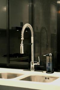 a bathroom sink with a faucet and a mirror at Adora's Place - Premium Room in Coron