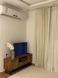 a living room with a tv and a curtain at استوديو هادي بموقع مميز in Riyadh