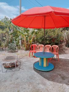 a table with a red umbrella next to chairs at MI RANCHITO in Sogamoso